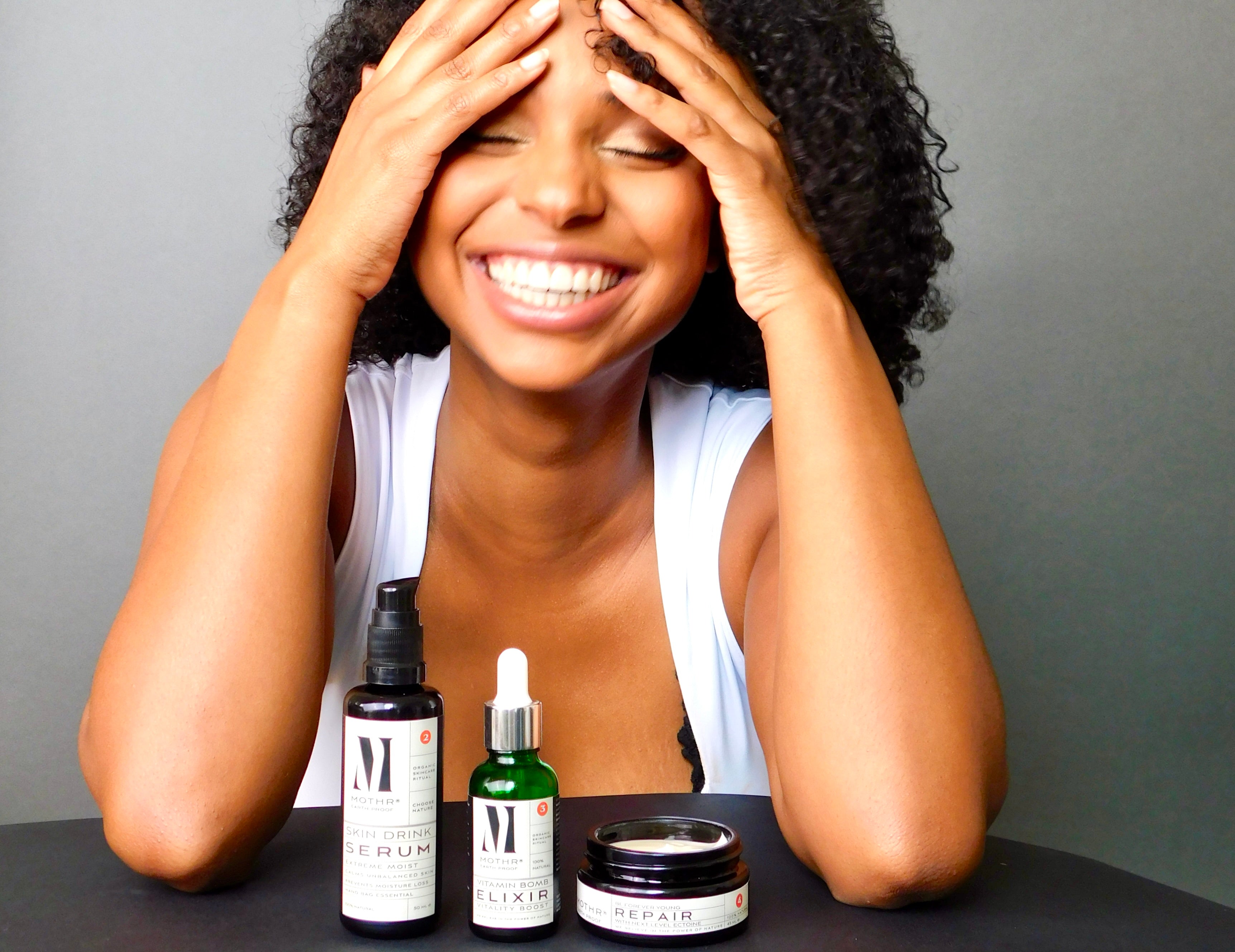 What is the ideal order of your skincare routine? Model with hands in hair
